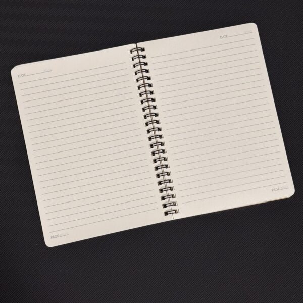Open spiral notebook with lined pages on a dark textured surface, blank pages ready for writing.